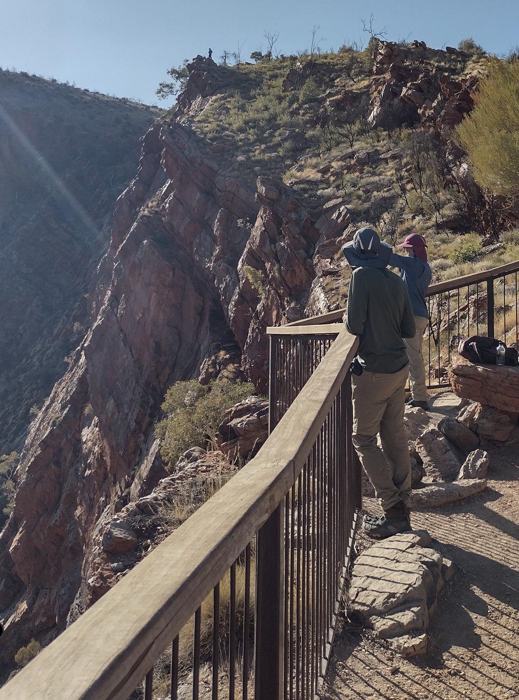Elise and Phil at the Serpentine Gorge Lookout. Fraser is silhouetted atop a rocky outcrop on the horizon.